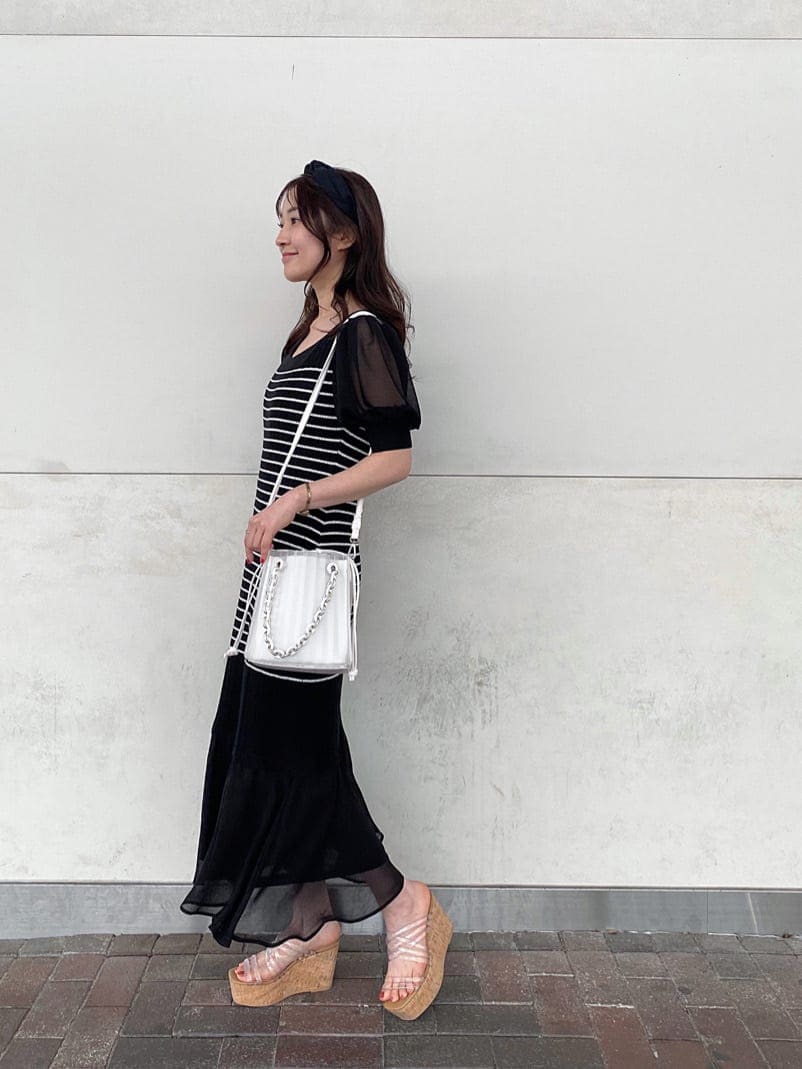 ブラック系のTシャツ/カットソー、ホワイト系のハンドバッグ、その他のサンダルを着用したレディースの春コーディネートの5枚目の写真