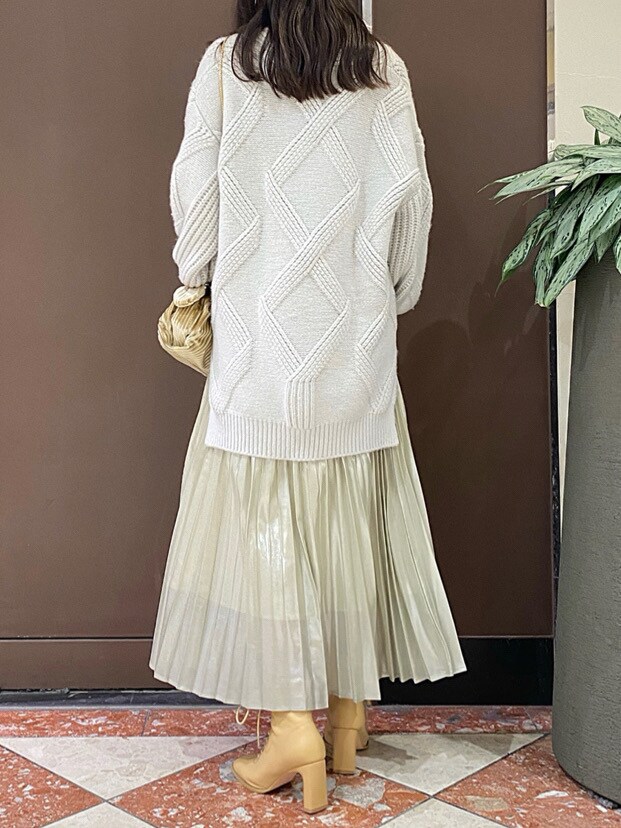 ベージュ系のクラッチバッグ、イエロー系のスカート、グレー系のニット/セーターを着用したレディースの秋コーディネートの4枚目の写真