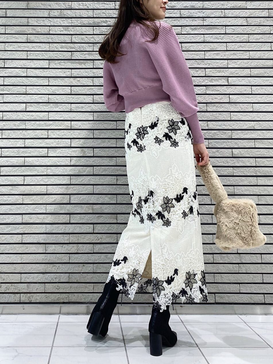 ホワイト系のスカート、ブラック系のブーツ、ピンク系のニット/セーターを着用したレディースの冬コーディネートの6枚目の写真