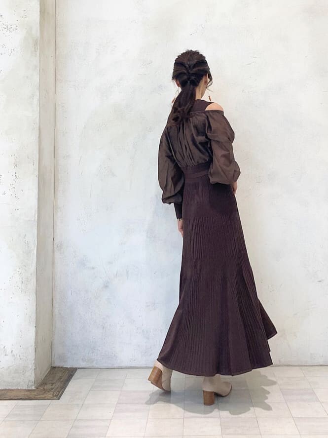 ベージュ系のハンドバッグ、ベージュ系のブーツ、ブラウン系のワンピースを着用したレディースの秋コーディネートの4枚目の写真