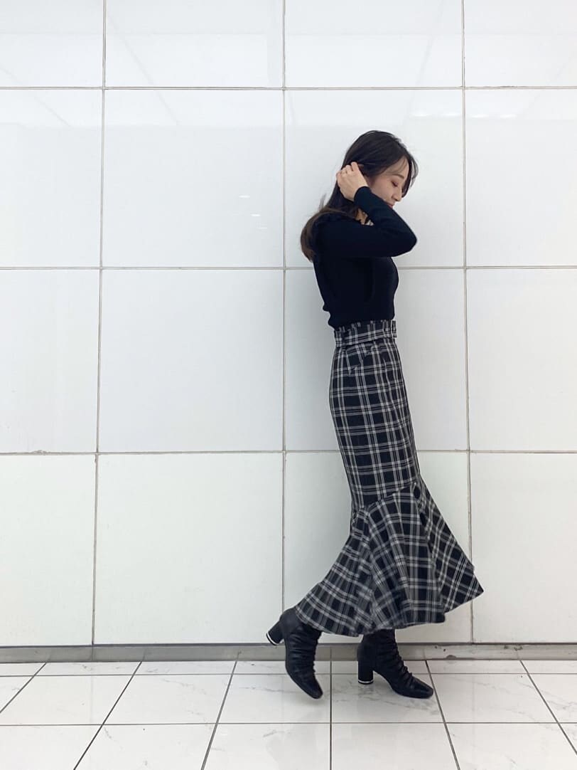 ブラック系のニット/セーター、ブラック系のその他シューズ、ブラック系のスカートを着用したレディースの秋コーディネートの2枚目の写真