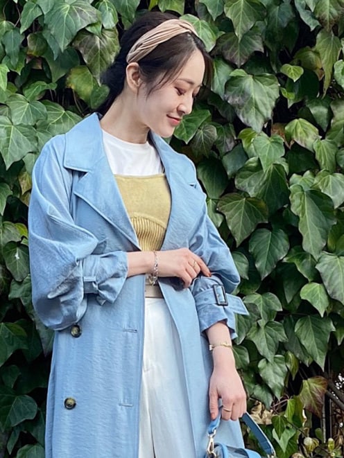 ブルー系のトレンチコート、イエロー系のサンダル、ホワイト系のその他パンツを着用したレディースの春コーディネートの7枚目の写真