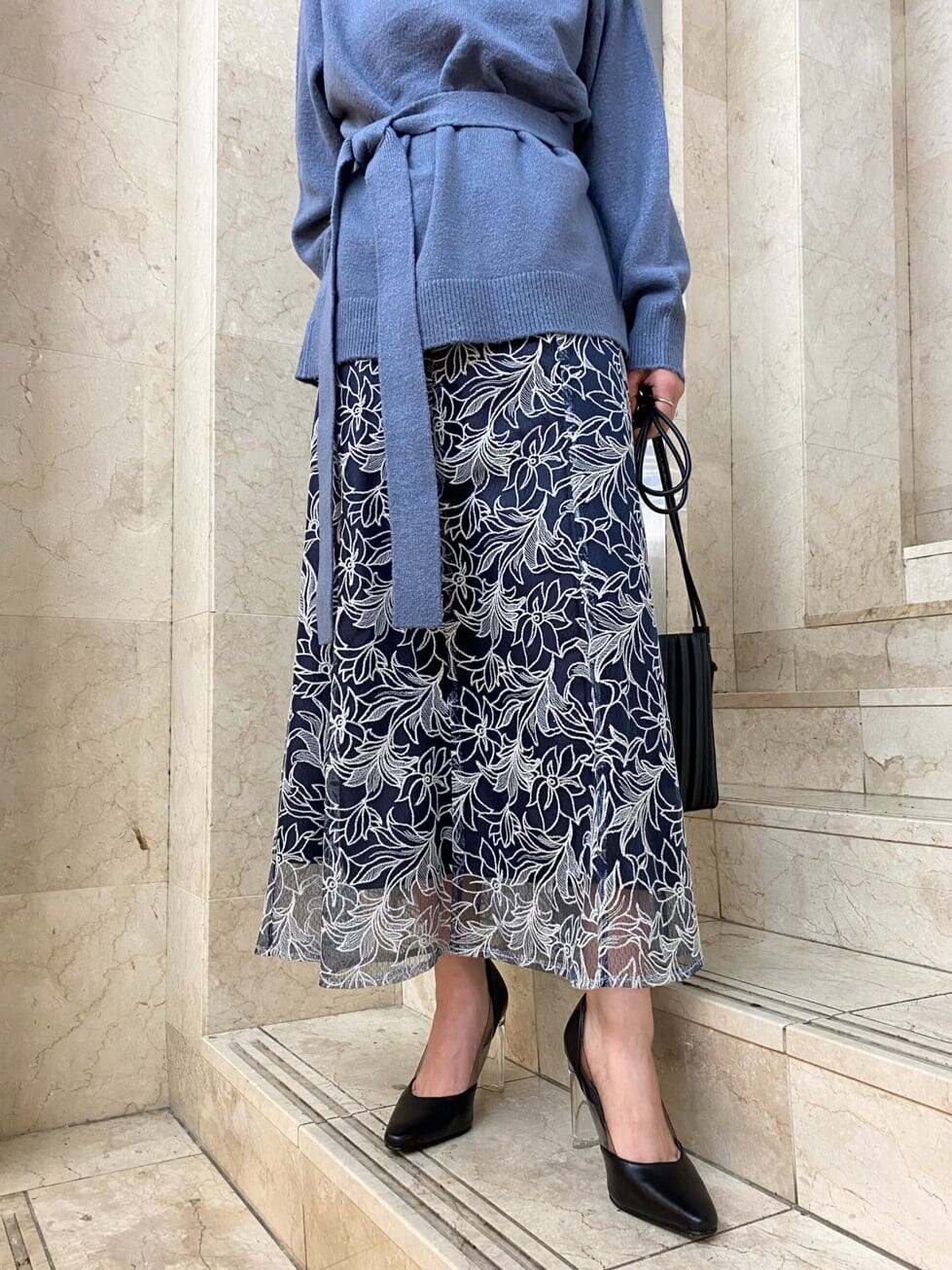 ピンク系のチェスターコート、ブラック系のパンプス、ブラック系のハンドバッグを着用したレディースの秋コーディネートの9枚目の写真