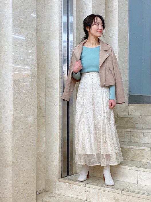 グリーン系のニット/セーター、ベージュ系のスカートを着用したレディースの冬コーディネートの2枚目の写真