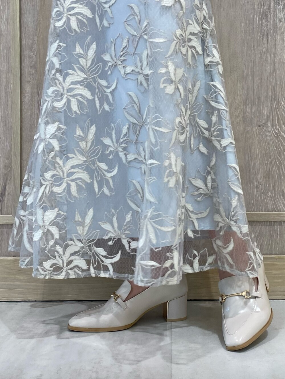 ブルー系のニット/セーター、ブルー系のスカート、ホワイト系のローファーを着用したレディースの秋コーディネートの8枚目の写真