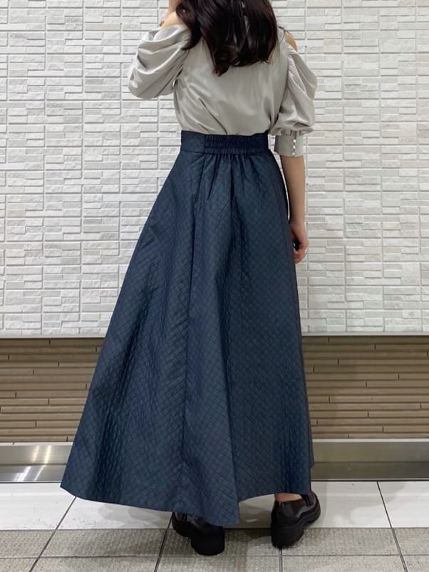 グレー系のスカート、グリーン系のシャツ/ブラウス、ブラウン系のローファーを着用したレディースの夏コーディネートの4枚目の写真