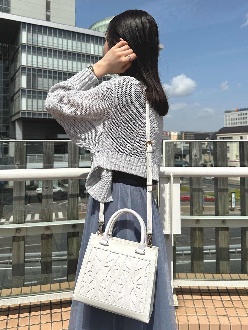 グレー系のカーディガン/ボレロ、ホワイト系のショルダーバッグ、ブルー系のワンピースを着用したレディースの春コーディネートの5枚目の写真