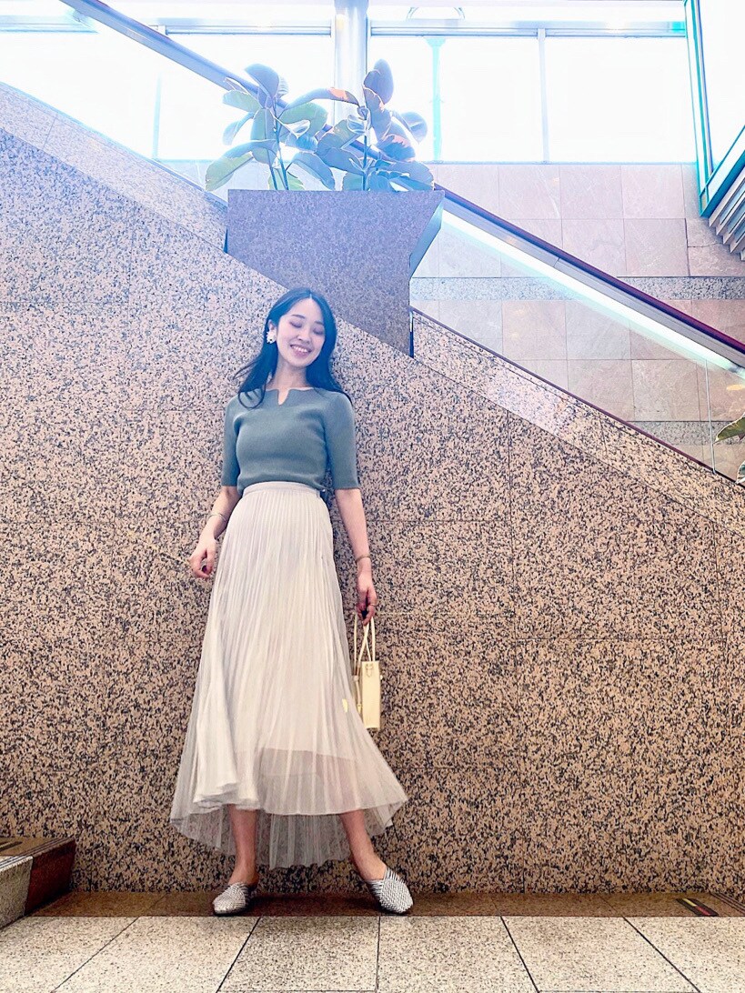 シルバー系のサンダル、シルバー系のスカート、ホワイト系のハンドバッグを着用したレディースの春コーディネートの5枚目の写真