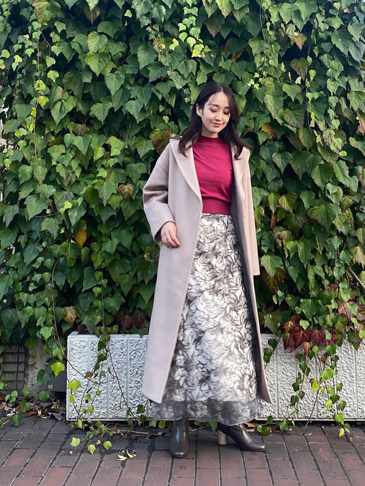 ブラウン系のその他シューズ、ベージュ系のステンカラーコート、レッド系のニット/セーターを着用したレディースの冬コーディネートの6枚目の写真