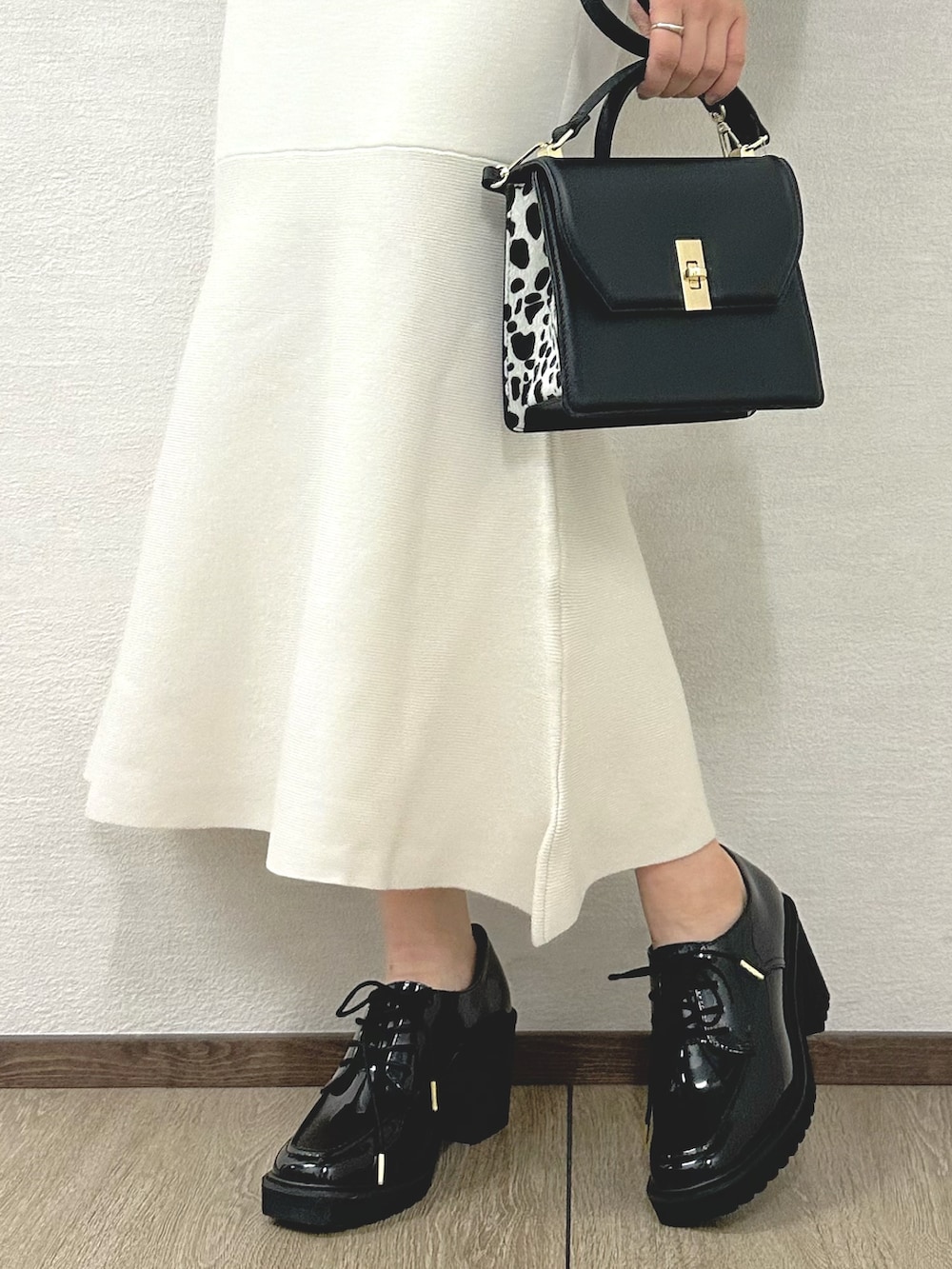 ホワイト系のワンピース、ブラック系のハンドバッグ、ブラック系のローファーを着用したレディースの秋コーディネートの8枚目の写真