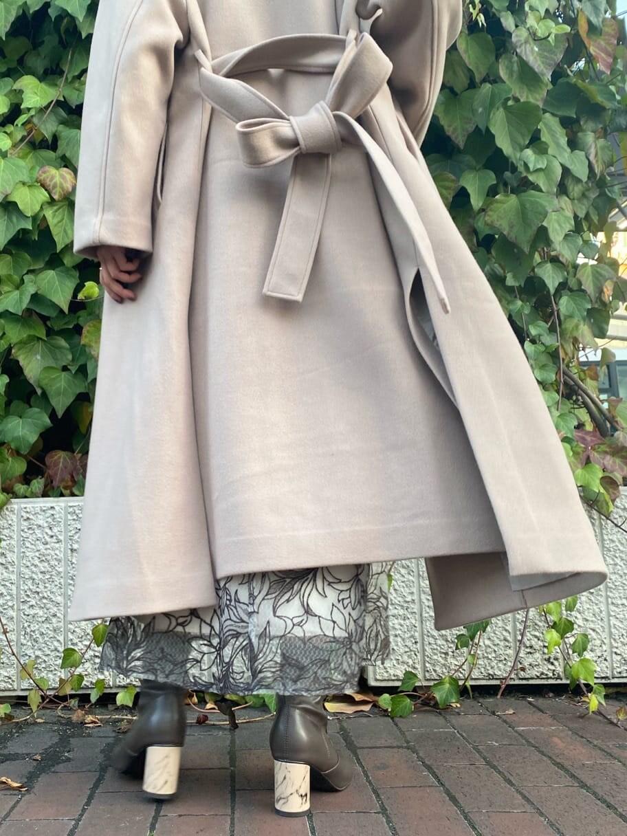 ブラウン系のその他シューズ、ベージュ系のステンカラーコート、レッド系のニット/セーターを着用したレディースの冬コーディネートの10枚目の写真