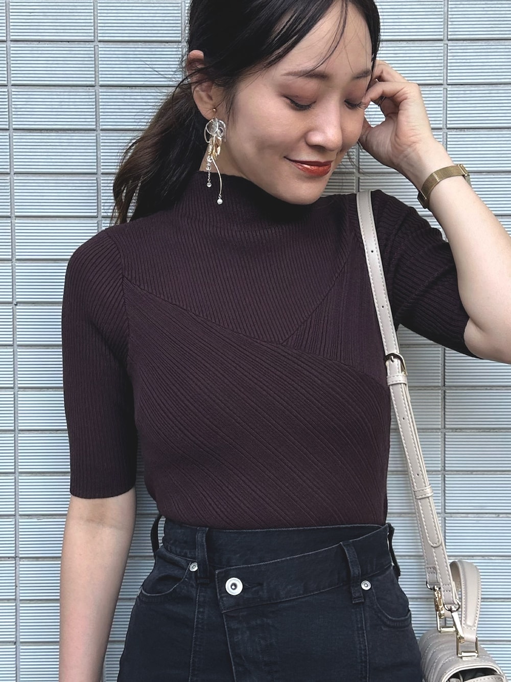 ブラウン系のニット/セーター、ブラック系のデニムスカート、ベージュ系のショルダーバッグを着用したレディースの秋コーディネートの4枚目の写真