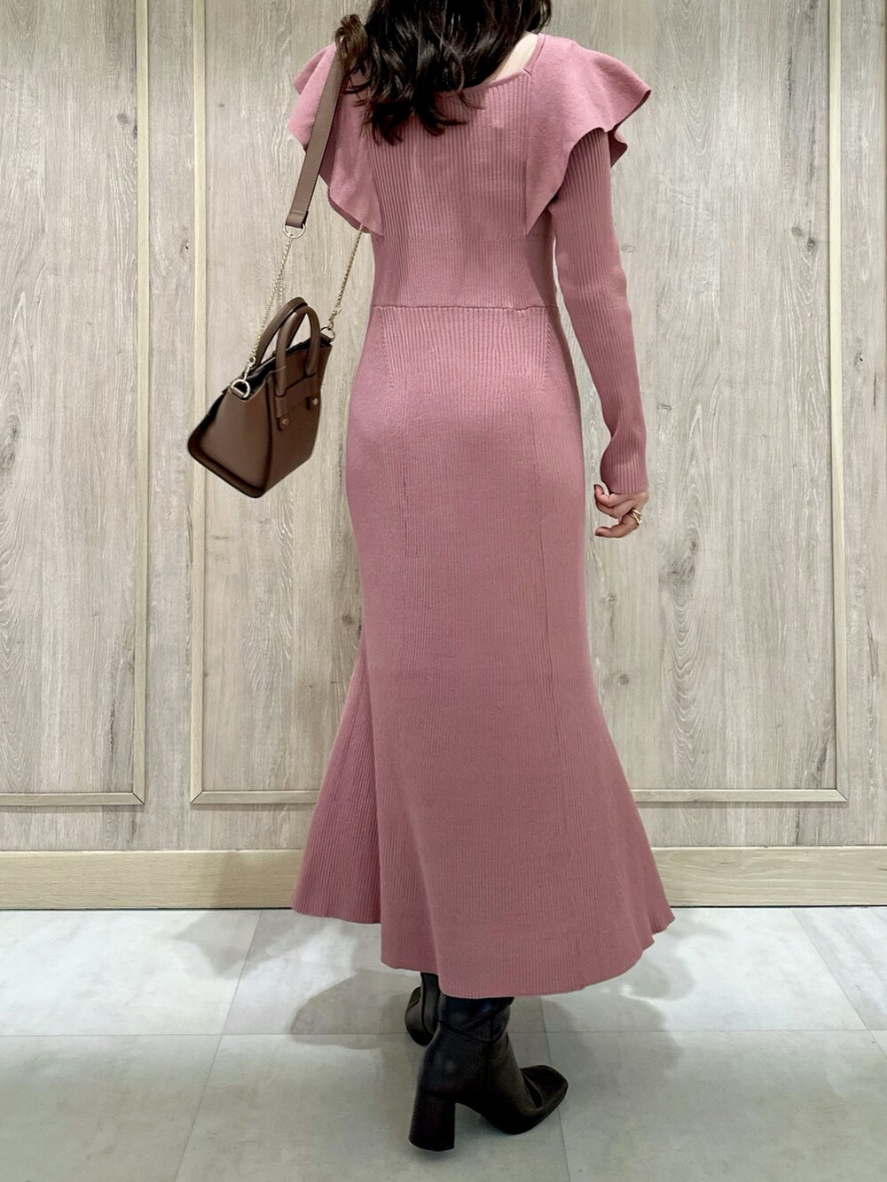 ピンク系のワンピース、ブラウン系のハンドバッグ、ブラウン系のブーツを着用したレディースの冬コーディネートの4枚目の写真