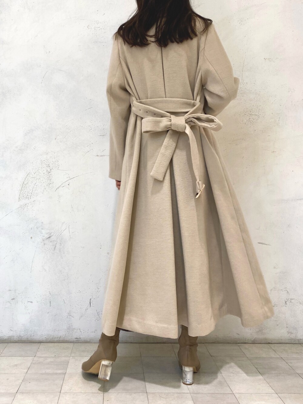 ホワイト系のワンピース、ベージュ系のブーツ、ベージュ系のチェスターコートを着用したレディースの冬コーディネートの4枚目の写真