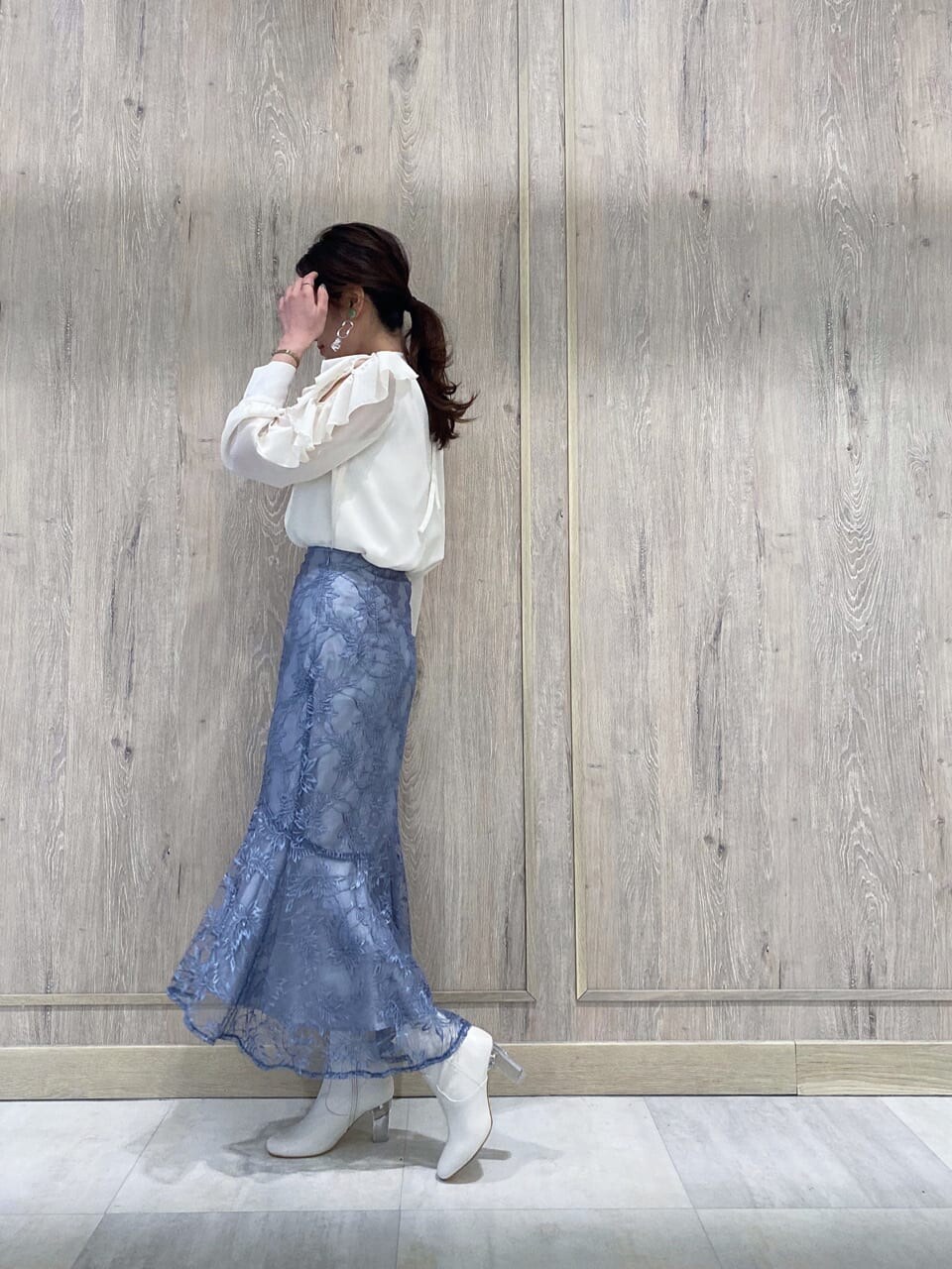 ブルー系のスカート、ホワイト系のTシャツ/カットソー、グリーン系のブルゾンを着用したレディースの冬コーディネートの2枚目の写真