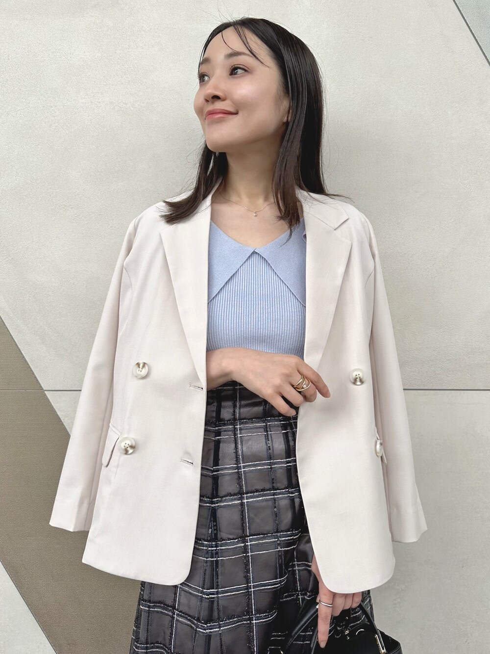 ブラック系のハンドバッグ、ブラック系のスカート、その他のサンダルを着用したレディースの春コーディネートの5枚目の写真