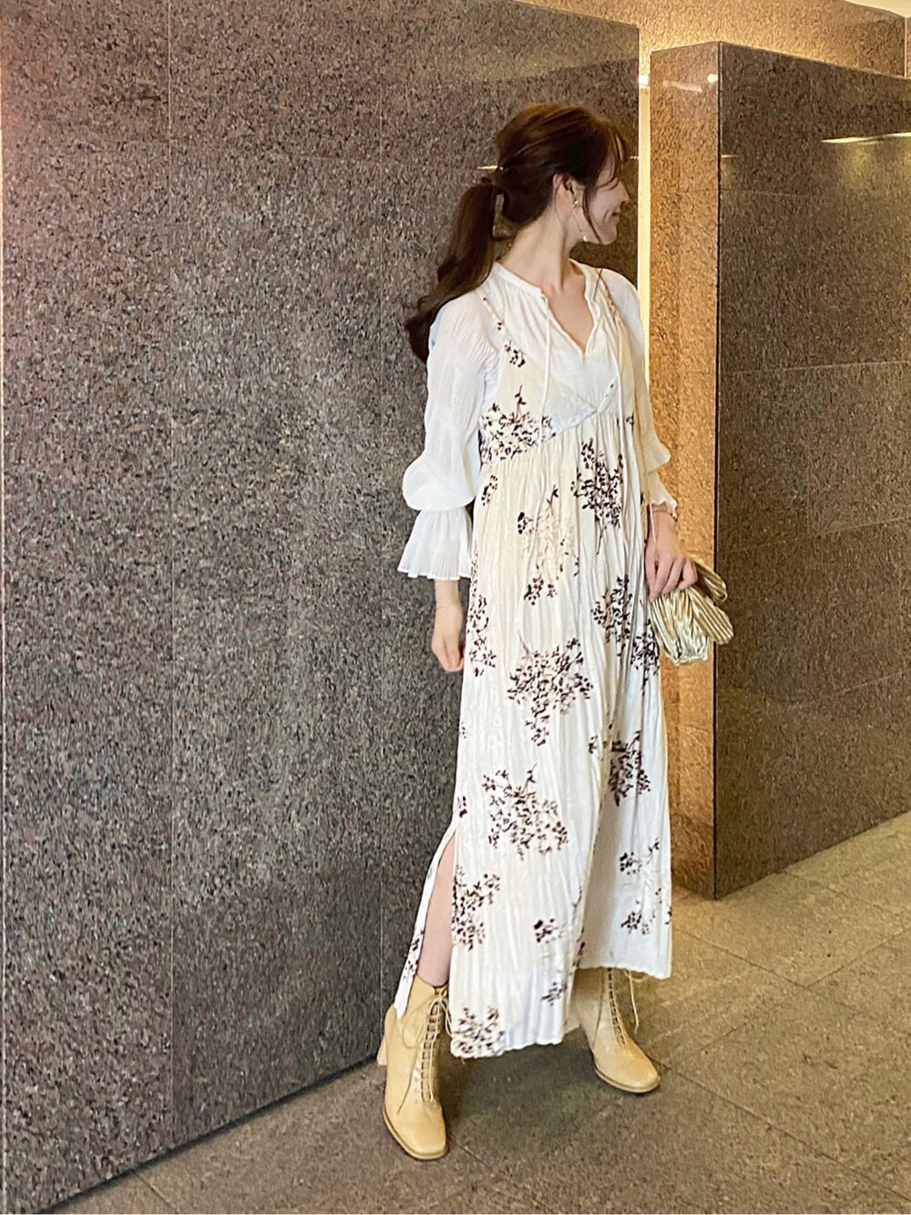 ベージュ系のワンピース、ホワイト系のシャツ/ブラウス、ベージュ系のクラッチバッグを着用したレディースの秋コーディネートの2枚目の写真