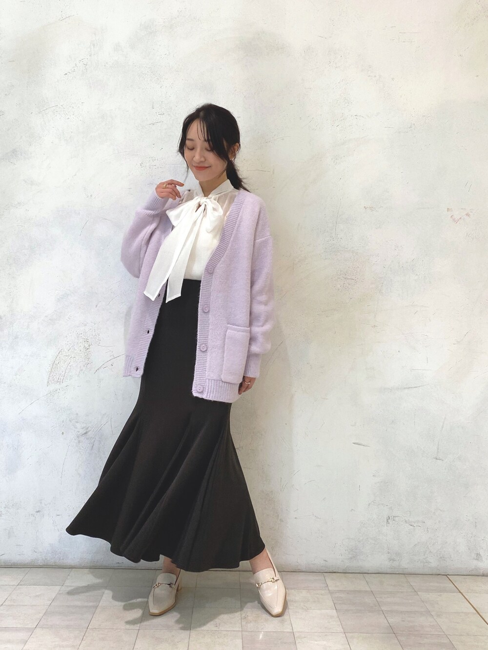 ホワイト系のローファー、パープル系のカーディガン/ボレロ、ブラウン系のスカートを着用したレディースの秋コーディネートの2枚目の写真