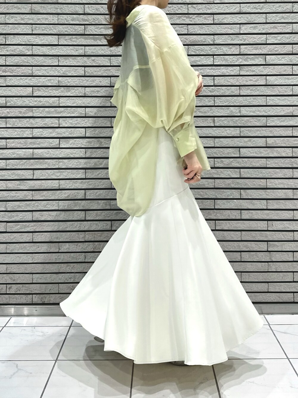 シルバー系のサンダル、ホワイト系のスカート、グレー系のニット/セーターを着用したレディースの春コーディネートの10枚目の写真