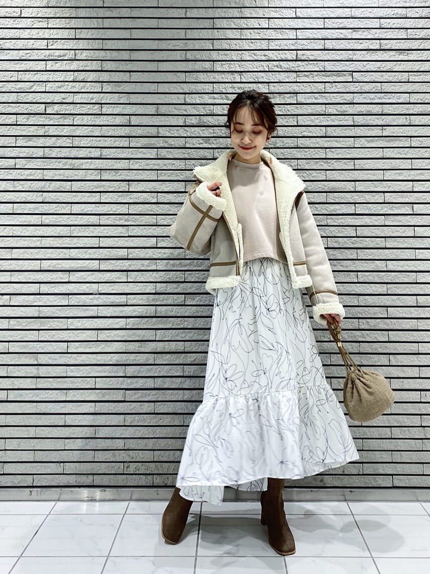 ベージュ系のハンドバッグ、ベージュ系のTシャツ/カットソー、ブルー系のワンピースを着用したレディースの秋コーディネートの2枚目の写真