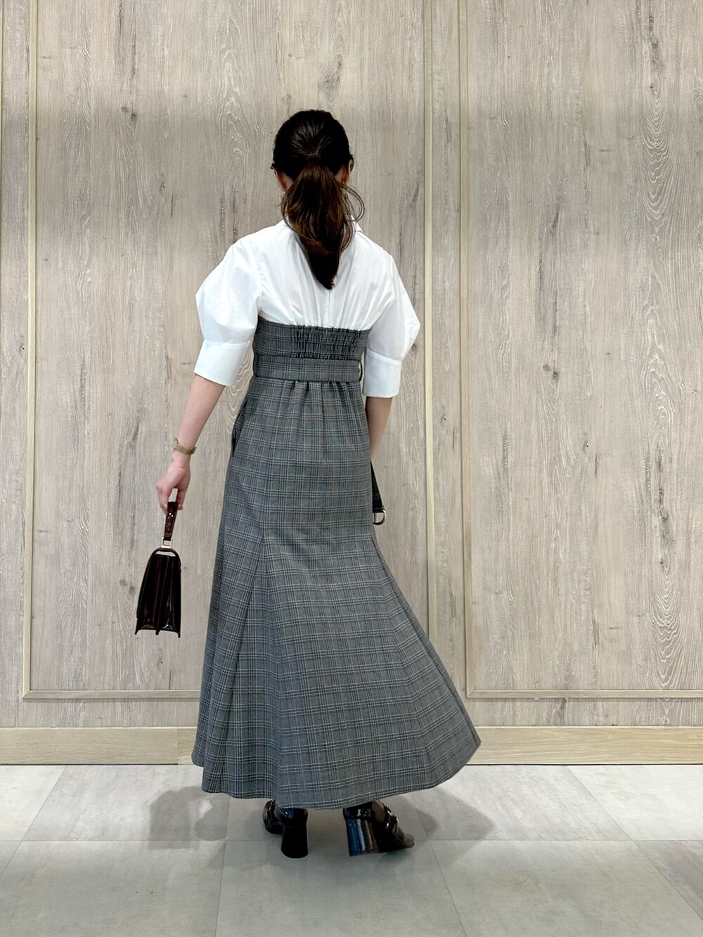 ブラウン系のパンプス、レッド系のハンドバッグ、その他のワンピースを着用したレディースの夏コーディネートの4枚目の写真