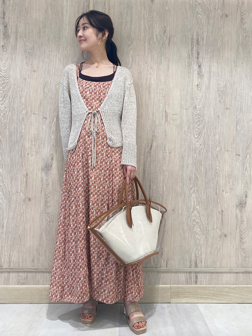 ブラウン系のトートバッグ、ベージュ系のカーディガン/ボレロ、オレンジ系のワンピースを着用したレディースの春コーディネートの4枚目の写真