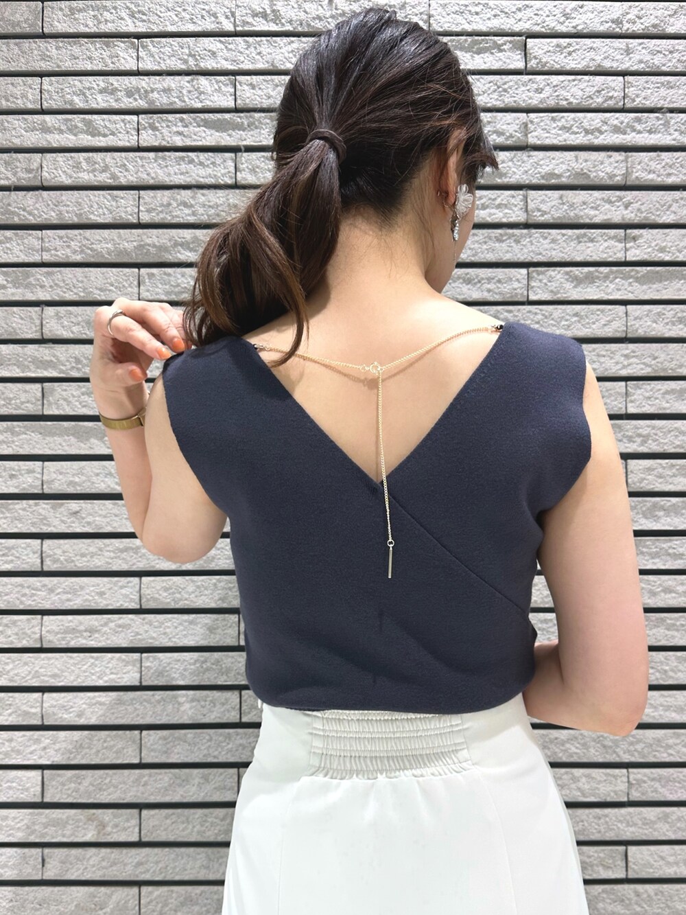 シルバー系のサンダル、ホワイト系のスカート、グレー系のニット/セーターを着用したレディースの春コーディネートの8枚目の写真