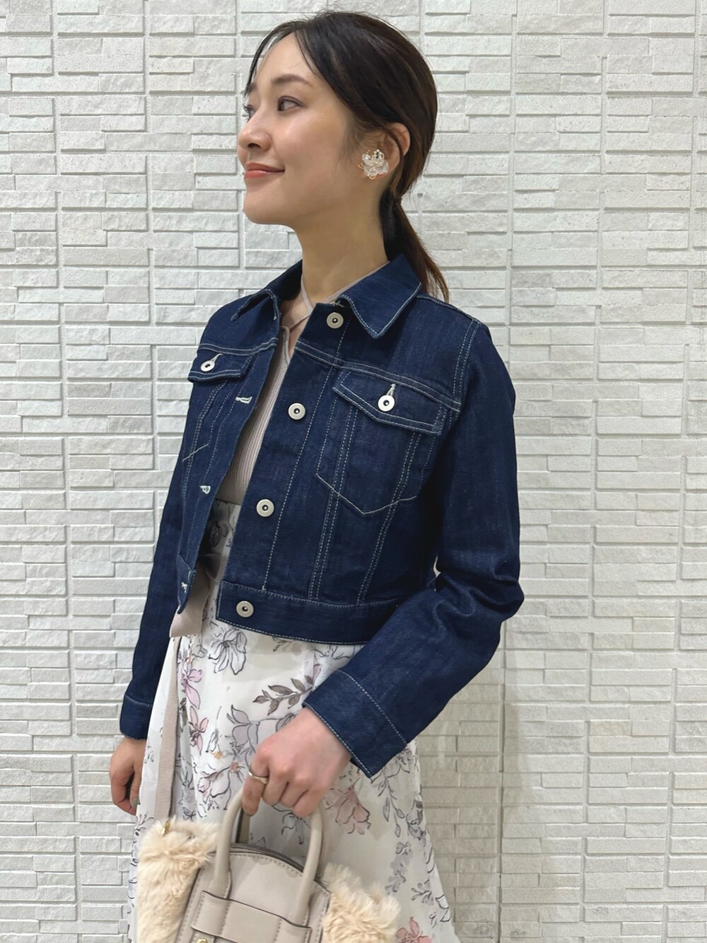 ブラウン系のブーツ、ホワイト系のハンドバッグ、ブルー系のデニムジャケットを着用したレディースの夏コーディネートの5枚目の写真