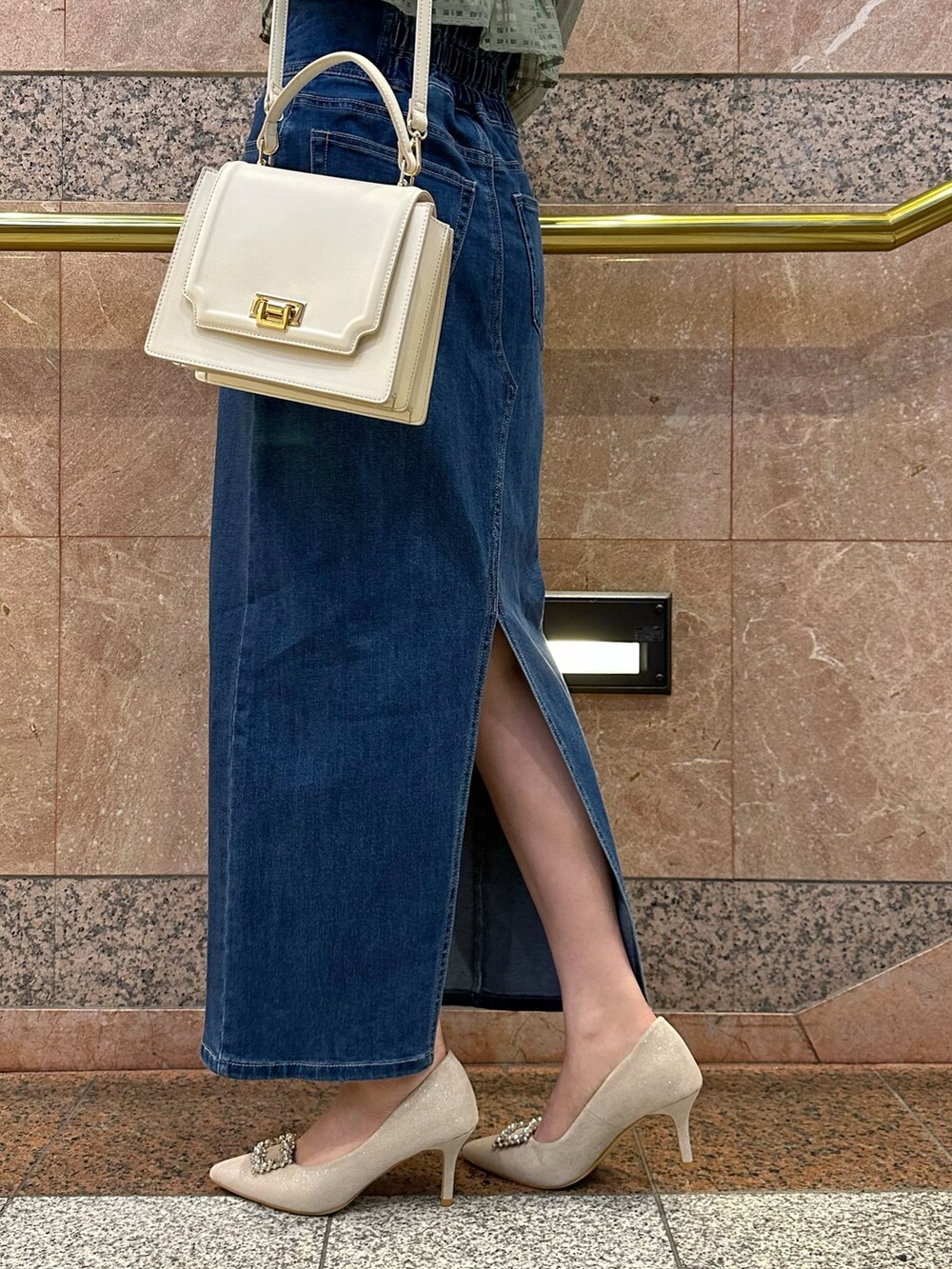 グリーン系のシャツ/ブラウス、ブルー系のデニムスカート、ベージュ系のパンプスを着用したレディースの冬コーディネートの10枚目の写真