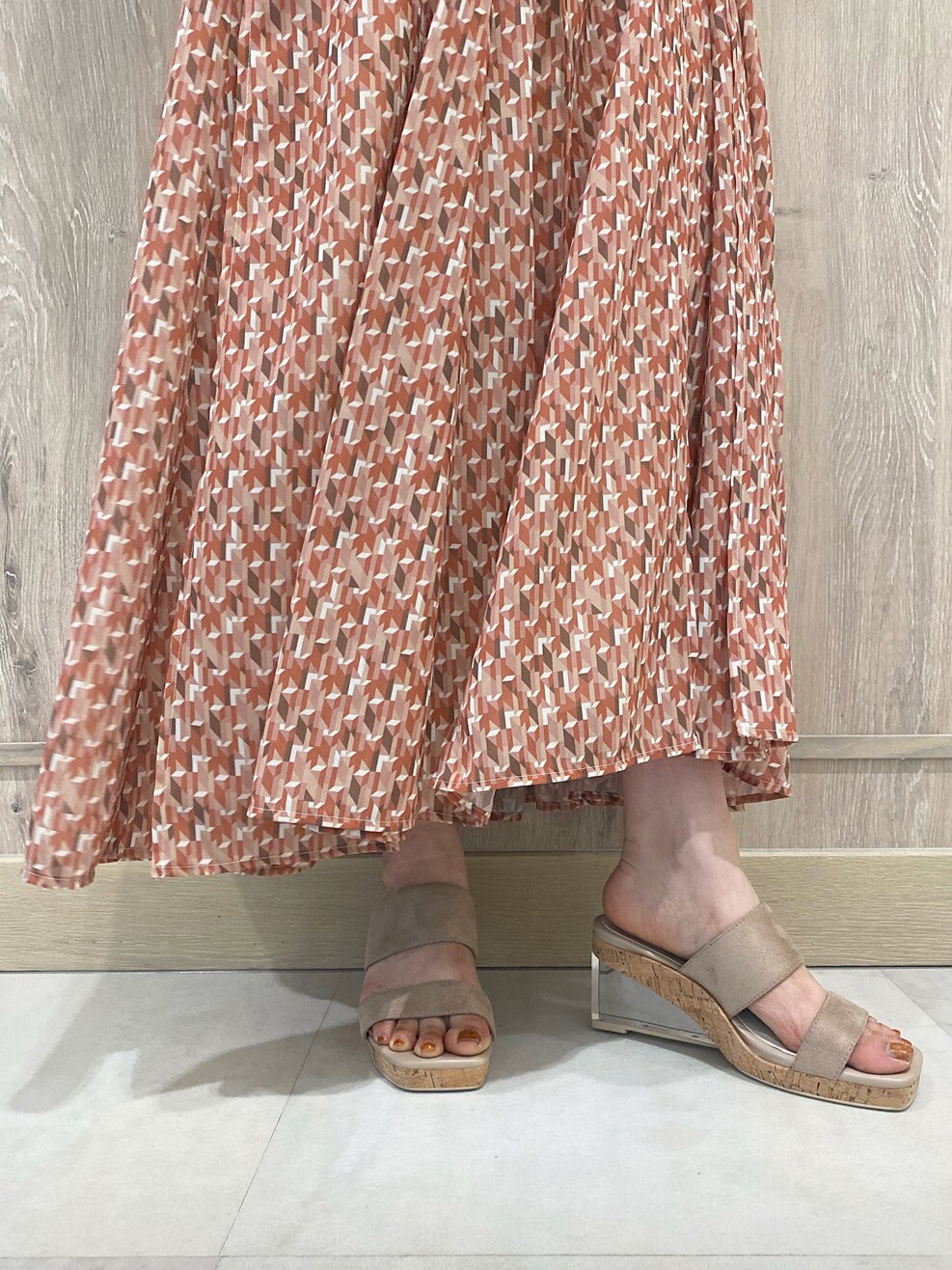 ブラウン系のトートバッグ、ベージュ系のカーディガン/ボレロ、オレンジ系のワンピースを着用したレディースの春コーディネートの6枚目の写真