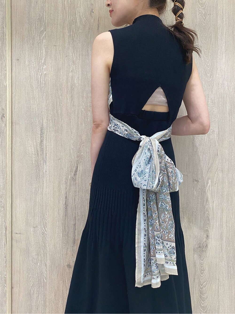 ブラック系のワンピース、イエロー系のサンダル、ホワイト系のハンドバッグを着用したレディースの夏コーディネートの6枚目の写真