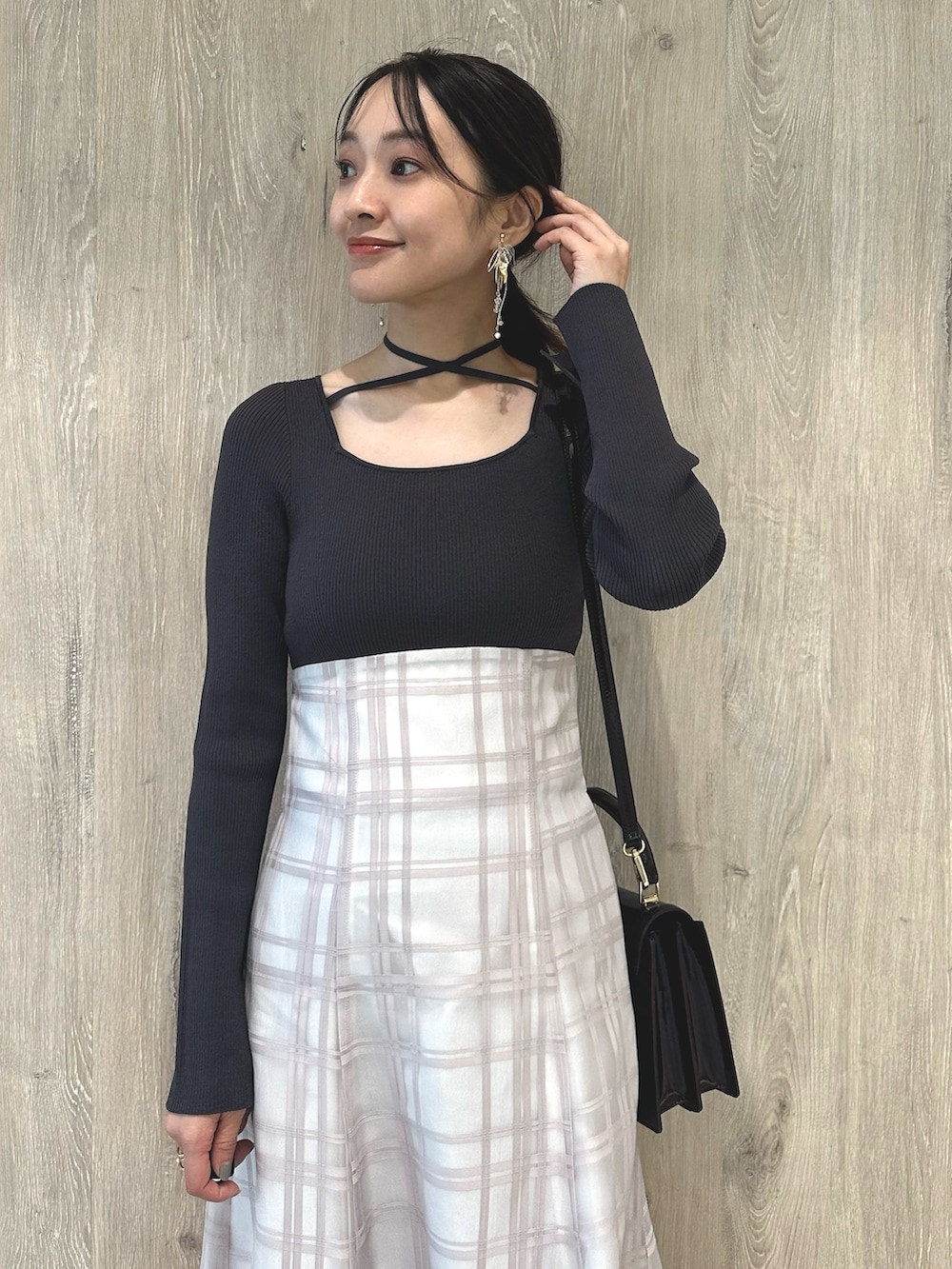 レッド系のハンドバッグ、ブラウン系のパンプス、グレー系のワンピースを着用したレディースの秋コーディネートの5枚目の写真