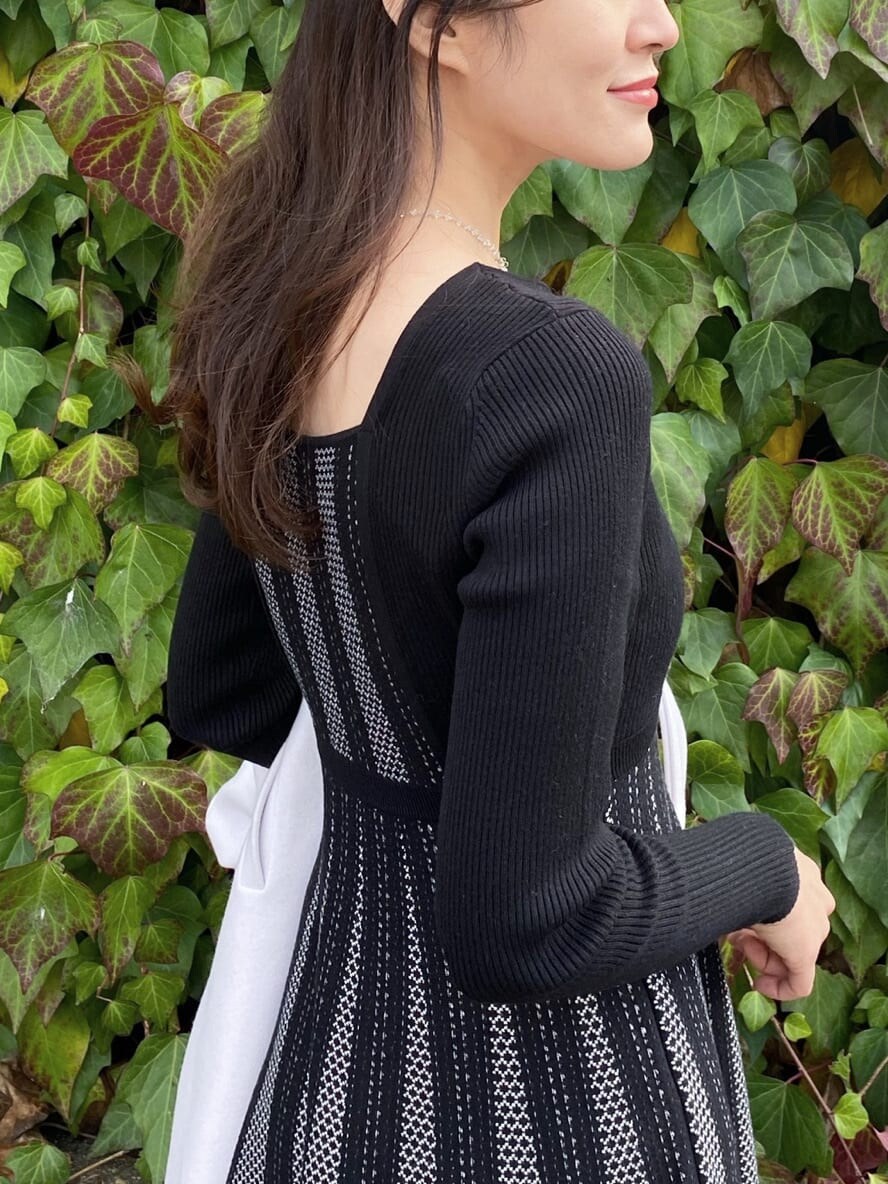 ブラック系のワンピース、ブラック系のその他シューズ、パープル系のステンカラーコートを着用したレディースの冬コーディネートの2枚目の写真