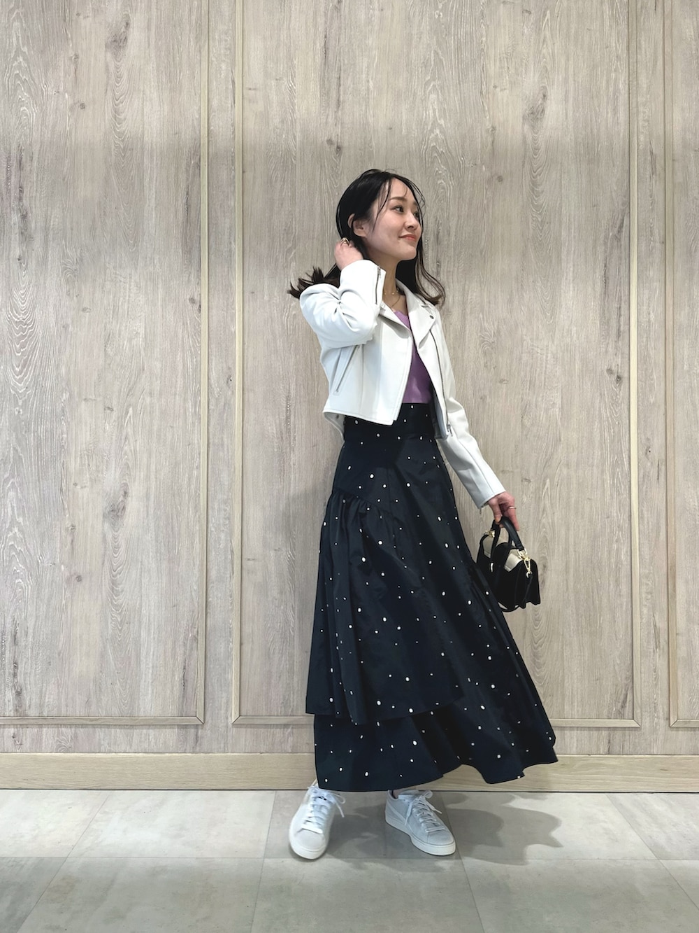 ピンク系のニット/セーター、ブラック系のハンドバッグ、その他のスカートを着用したレディースの春コーディネートの2枚目の写真