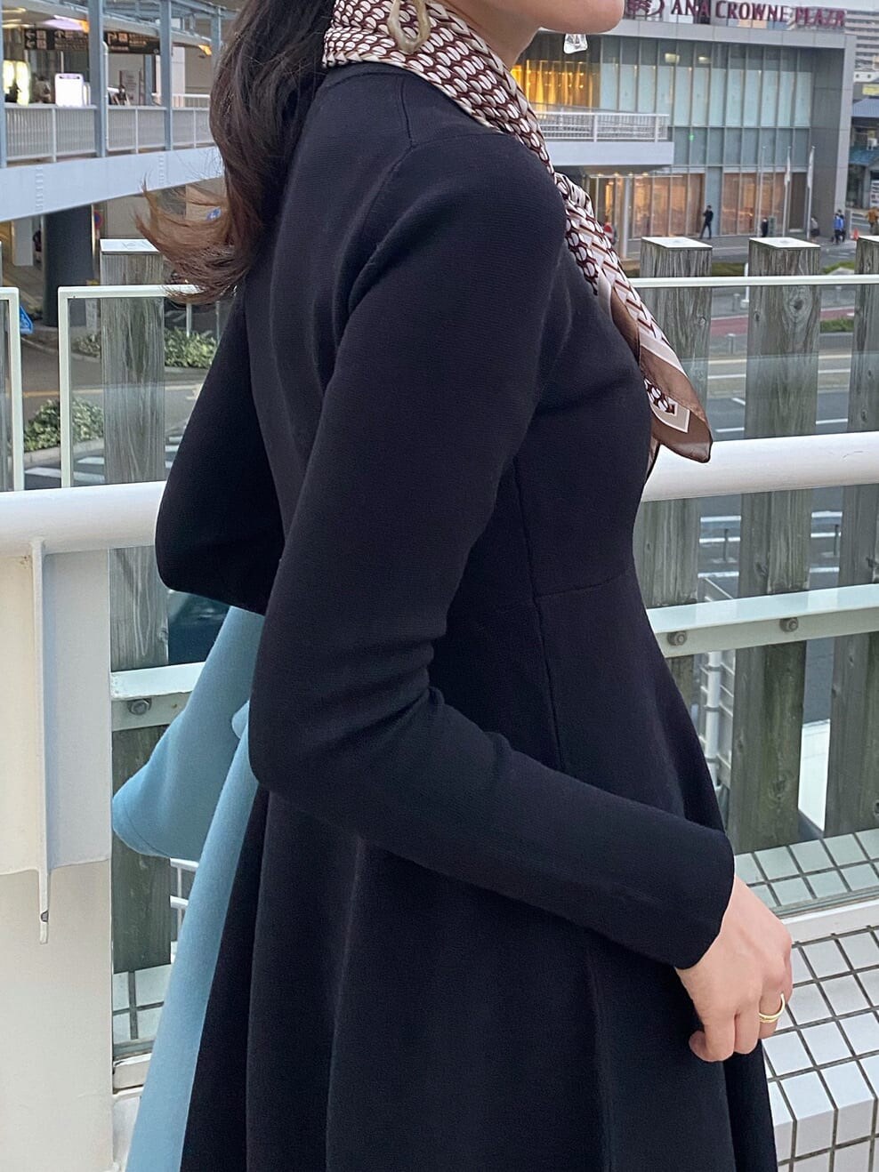 ブラウン系のその他シューズ、ブルー系のノーカラーコート、ブラック系のワンピースを着用したレディースの秋コーディネートの5枚目の写真