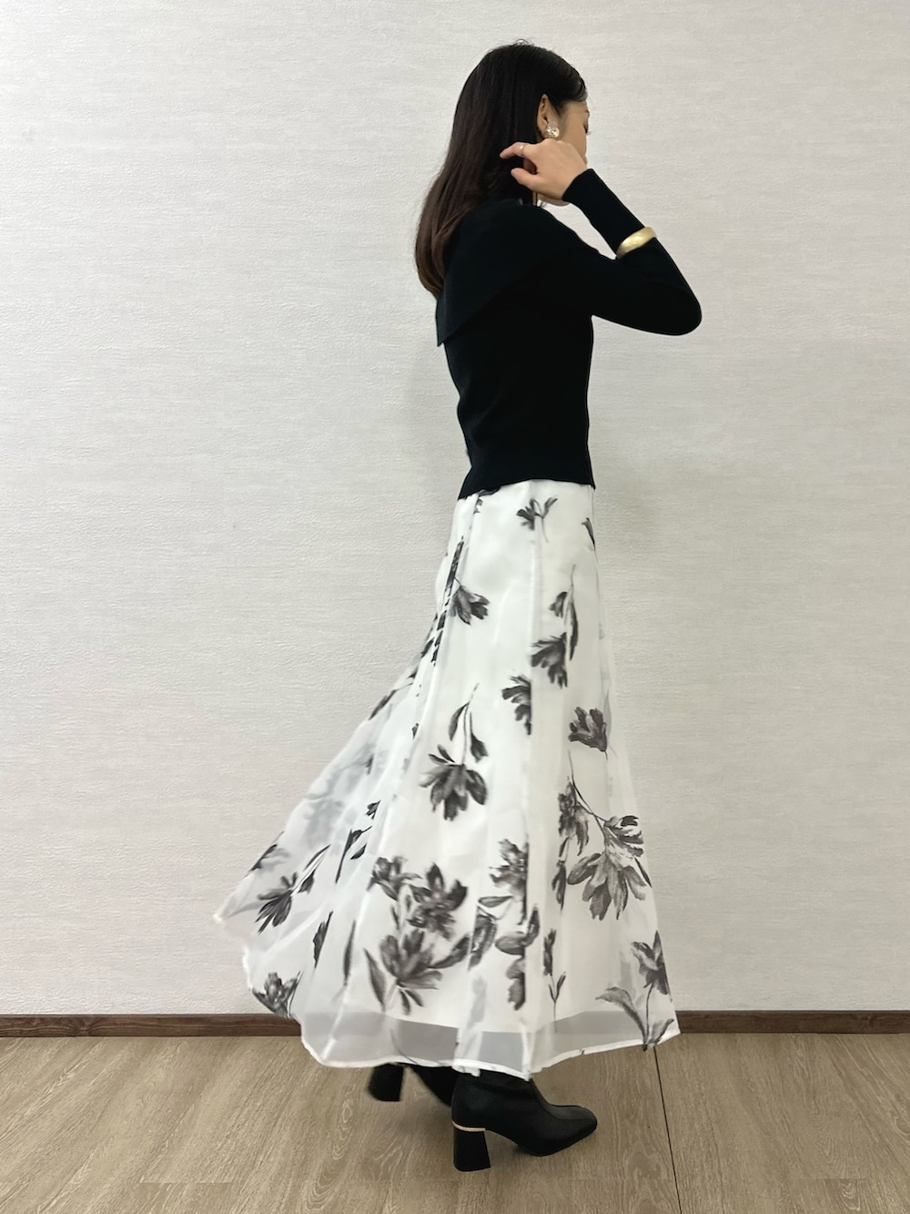 ブラック系のニット/セーター、ブラック系のブーツ、レッド系のハンドバッグを着用したレディースの秋コーディネートの3枚目の写真