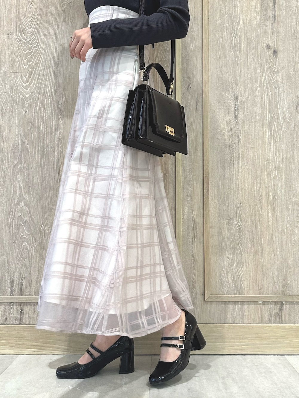 レッド系のハンドバッグ、ブラウン系のパンプス、グレー系のワンピースを着用したレディースの秋コーディネートの9枚目の写真