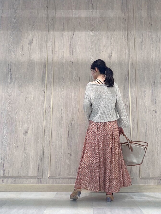 ブラウン系のトートバッグ、ベージュ系のカーディガン/ボレロ、オレンジ系のワンピースを着用したレディースの春コーディネートの3枚目の写真