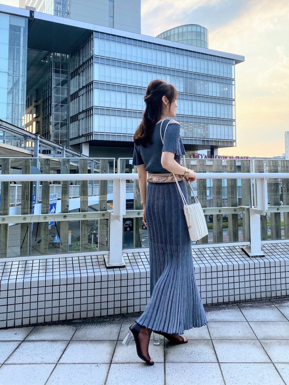 ブルー系のワンピース、ブラウン系のその他シューズ、ホワイト系のハンドバッグを着用したレディースの夏コーディネートの3枚目の写真