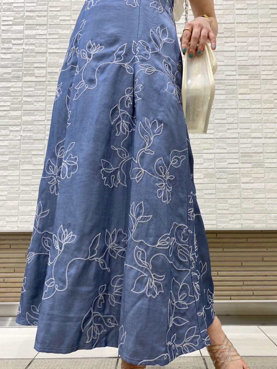 ホワイト系のショルダーバッグ、ブルー系のスカート、ホワイト系のニット/セーターを着用したレディースの夏コーディネートの4枚目の写真