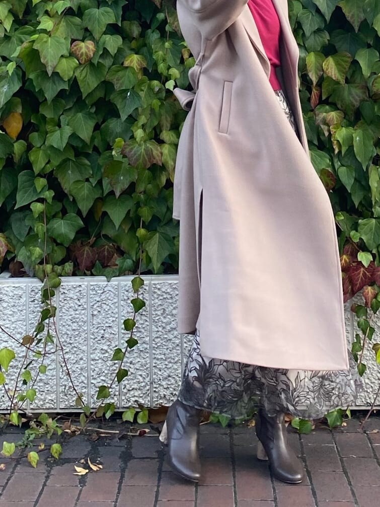 ブラウン系のその他シューズ、ベージュ系のステンカラーコート、レッド系のニット/セーターを着用したレディースの冬コーディネートの9枚目の写真