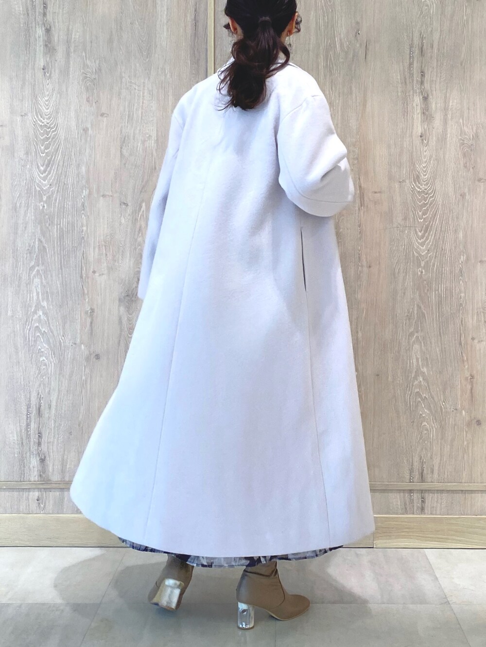 ベージュ系のブーツ、ピンク系のチェスターコート、ブラック系のワンピースを着用したレディースの冬コーディネートの5枚目の写真