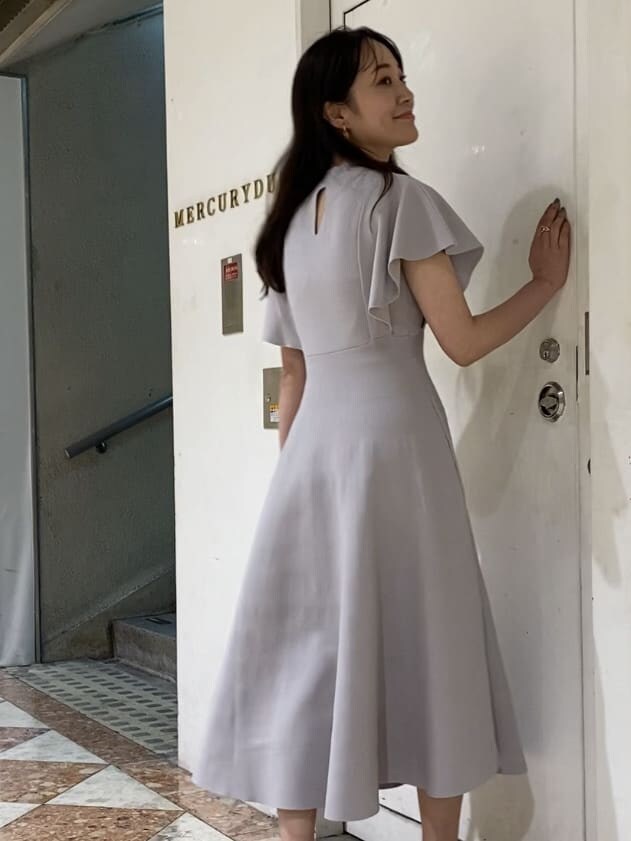 グレー系のワンピース、その他のサンダル、ホワイト系のショルダーバッグを着用したレディースの夏コーディネートの2枚目の写真