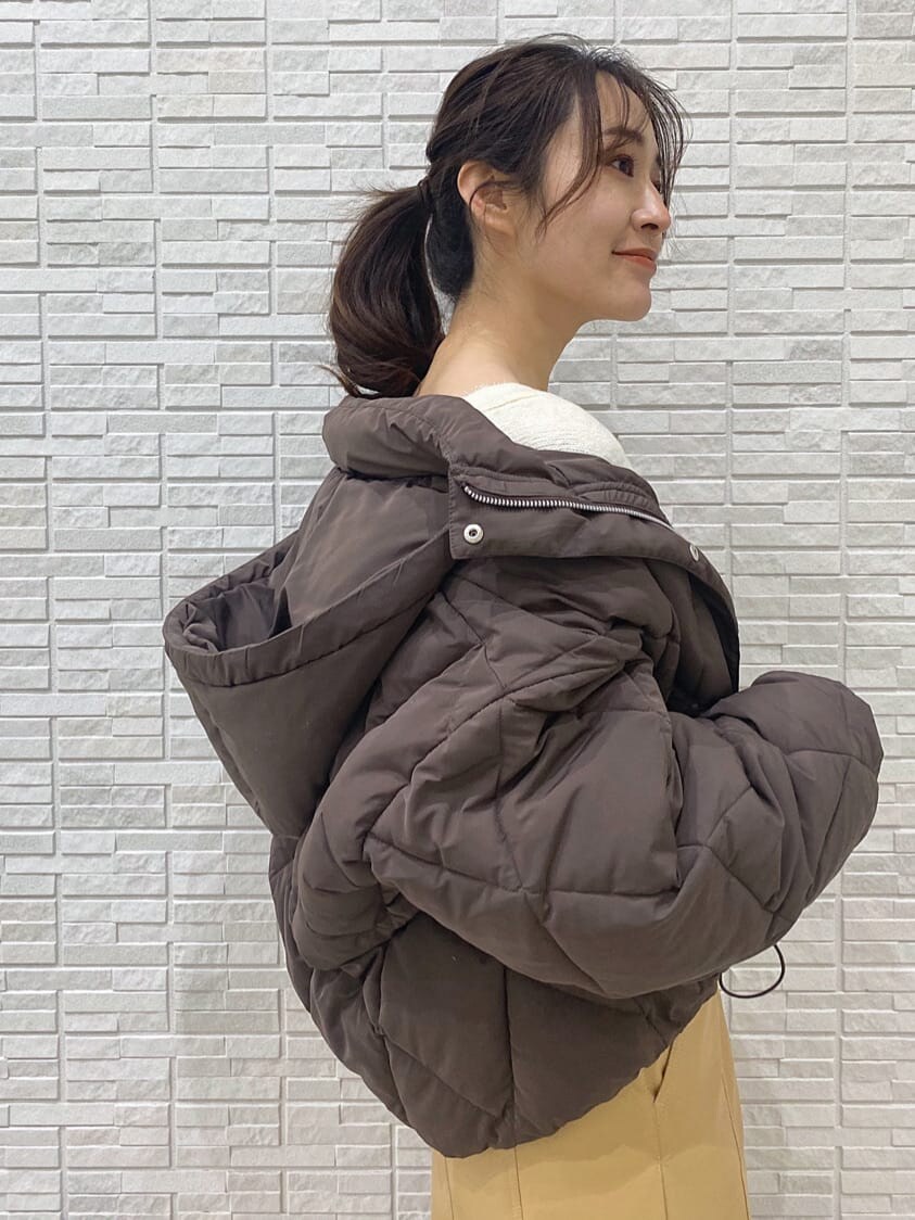 ベージュ系のスカート、ブラウン系のブルゾン、ブラウン系のハンドバッグを着用したレディースの冬コーディネートの4枚目の写真