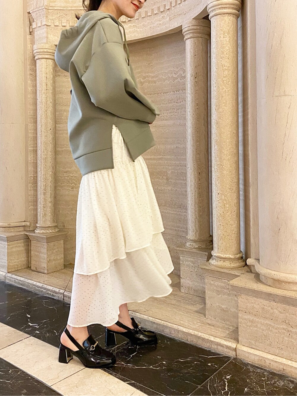 ホワイト系のスカート、ブラック系のローファー、ホワイト系のハンドバッグを着用したレディースの冬コーディネートの4枚目の写真