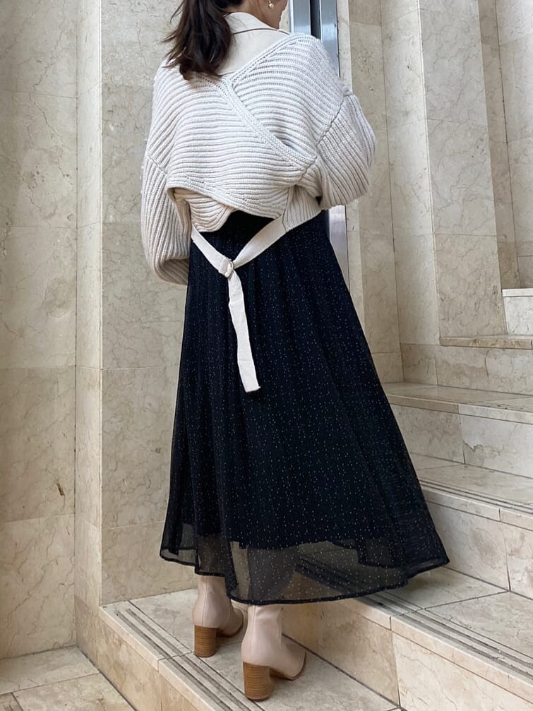 ベージュ系のハンドバッグ、ホワイト系のテーラードジャケット、ベージュ系のブーツを着用したレディースの秋コーディネートの2枚目の写真