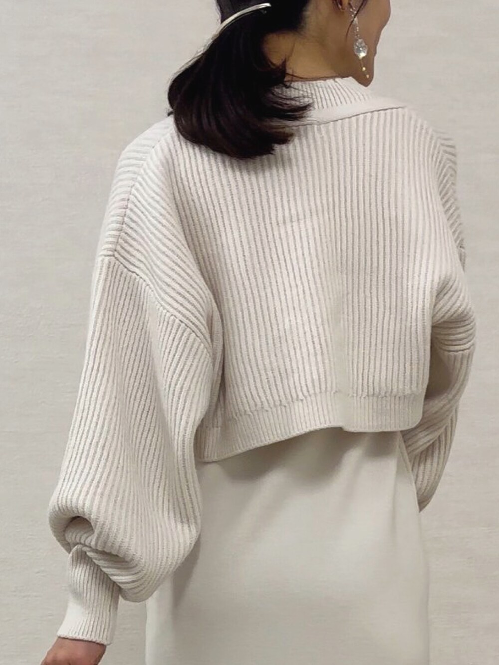 ホワイト系のワンピース、シルバー系のハンドバッグ、ブラック系のブーツを着用したレディースの秋コーディネートの6枚目の写真