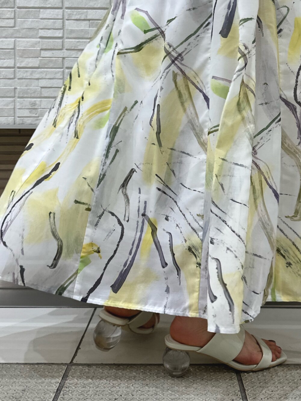 ホワイト系のキャミソール、ホワイト系のサンダル、イエロー系のスカートを着用したレディースの夏コーディネートの9枚目の写真