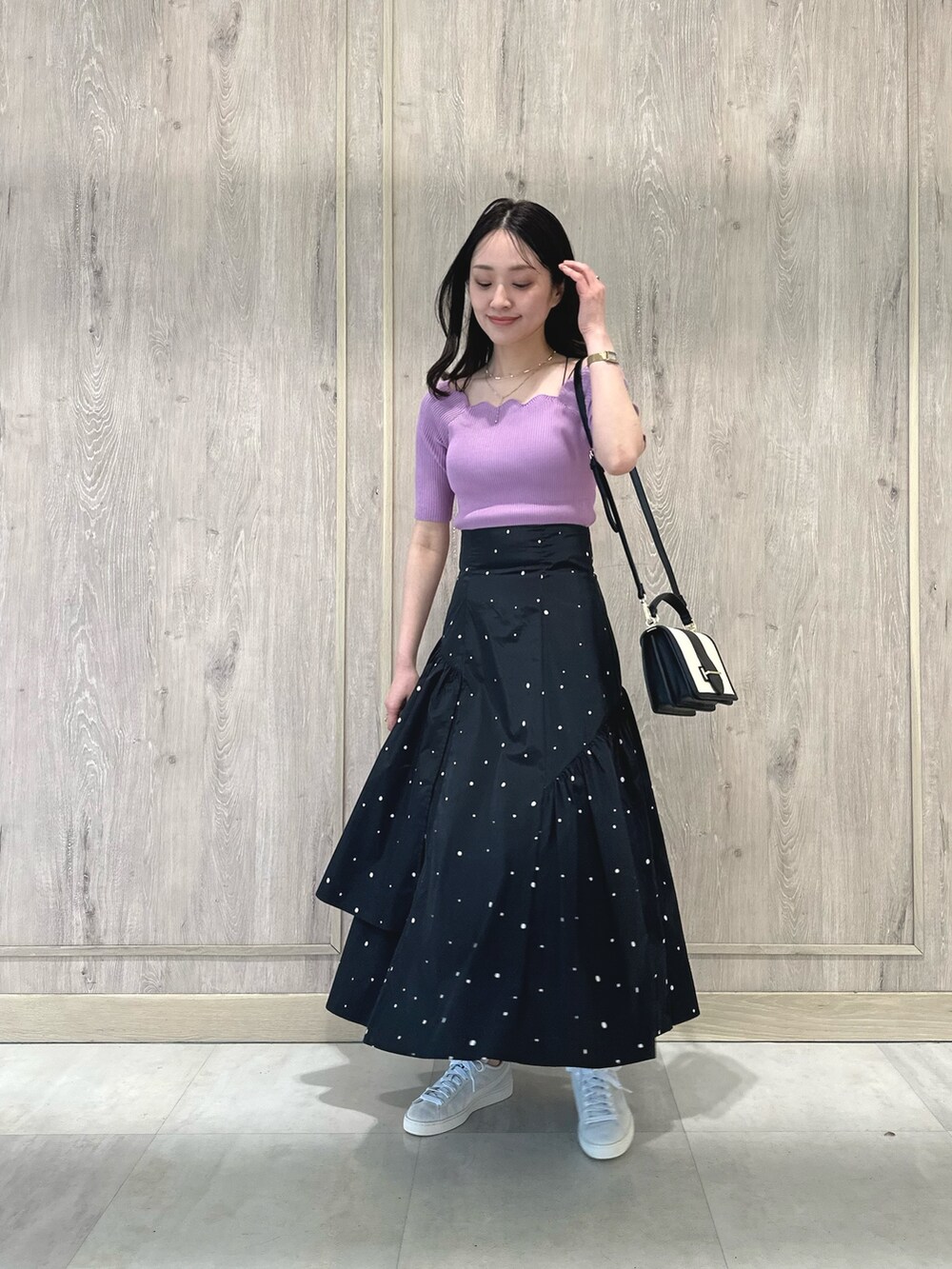 ピンク系のニット/セーター、その他のスカート、ブラック系のハンドバッグを着用したレディースの春コーディネートの2枚目の写真