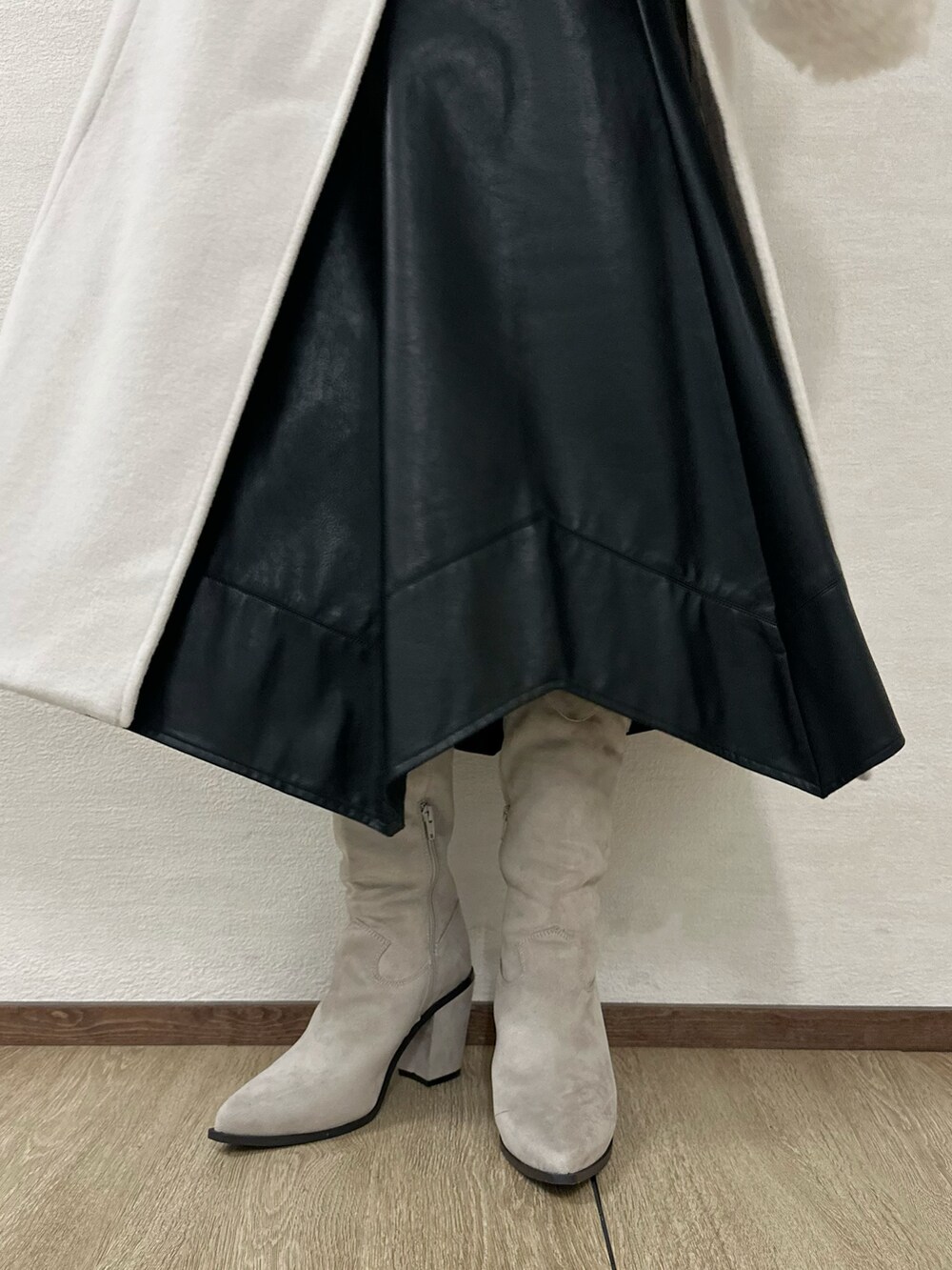 グレー系のブーツ、グレー系のニット/セーター、ブラック系のスカートを着用したレディースの冬コーディネートの7枚目の写真